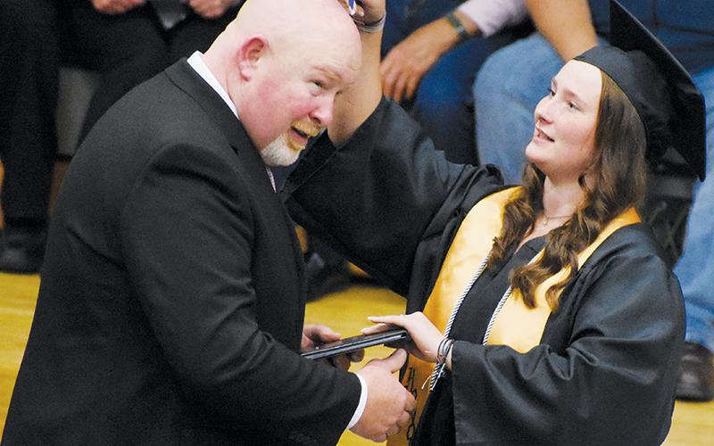 Abigayle Lancaster broke up the processional line of students receiving their diplomas from Robbinsville High School Principal David Matheson by making sure not one spot was missed on his head ... Photo by Kevin Hensley/editor@grahamstar.com