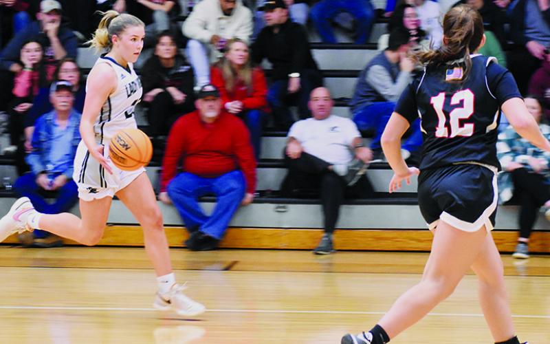 With Andrews’ Kinleigh Queen (12) sprinting to cut off the progress, Liz Carpenter breaks toward the home basket during Tuesday’s loss to the Lady Wildcats. Despite Carpenter’s 21-point showing, the Knights suffered their first setback of the season. Photo by Fala Welch/The Graham Star