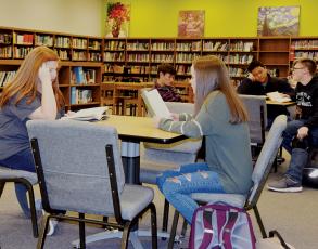 Lilly Lancaster and Charida Willis (front table), as well as Wilhem Crisp, Russell Hooper and Eddie Brooms (back table) persue through some books at Robbinsville High School on Monday. Graham County Schools received a grade of "C" for their literacy levels during the 2018-19 year. Photo by Art Miller/amiller@grahamstar.com