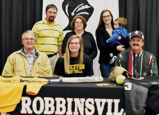 Lady Knights senior Gracye Burchfield (seated, center) signed with Pfeiffer University on Dec. 4. Seated with Burchfield are Larry Icenhower (left) and Gary Icenhower. Standing in back (from left) are Brent Icenhower, Barbara Icenhower, Hannah Lewis and Jordan Lewis. Photo by Kevin Hensley/editor@grahamstar.com