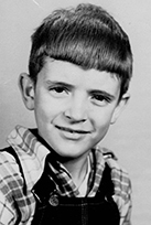 The writer enjoys his “Christmas Overalls” as a child in the 1950s.
