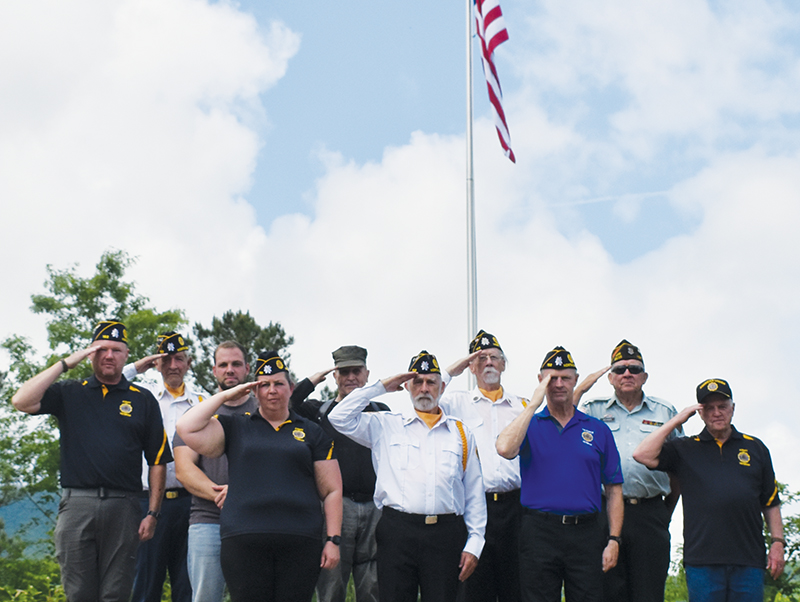 Veterans stand in front of the massive flag that was raised for the first time Memorial Day off Old Tallulah Road. All names are listed from left in each row. Front row: Amanda Gyongyos, Rudy Leopold, Barry Watkins and Billy Cable. Second row: Travis Brooks, Caleb Stiles, Joseph Vasquez, Hubert Merchant and Buddy Adams. Standing in back is Harold Phillips. Photo by Lexie Anderson/The Graham Star