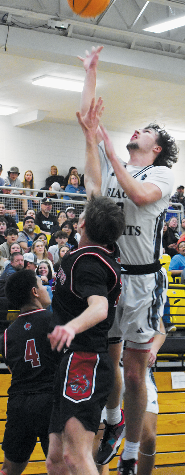 Bryce Adams pushes a shot over the defense of Andrews’ Ty Clark and Kegan Ellis in the second half of Saturday’s conference-tournament finale. Adams ended his basketball tenure with the Knights as the program’s all-time leading scorer. Photo by Kevin Hensley/sports@grahamstar.com