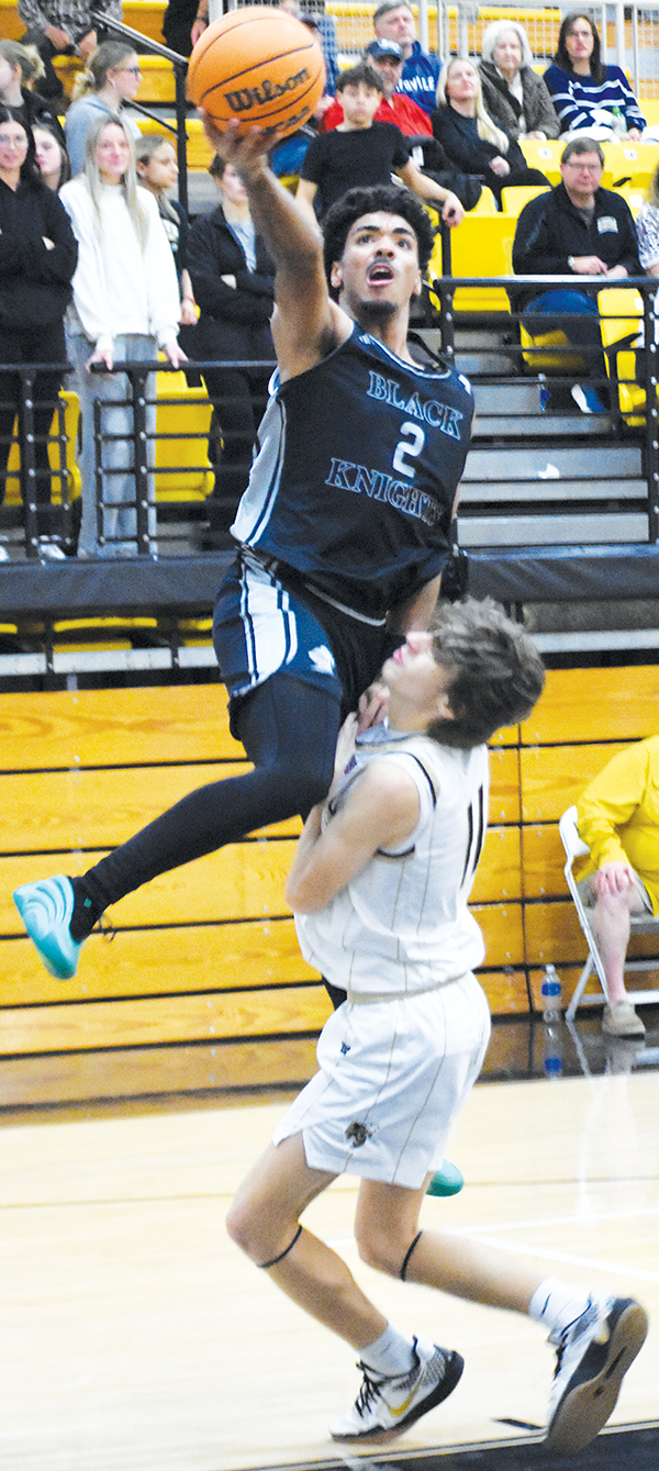 Kristian Bauzo sails over Hayesville's Brady Reynolds for a first-half basket attempt Friday. Photo by Kevin Hensley/sports@grahamstar.com