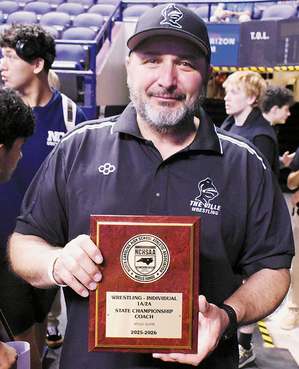 Robbinsville Wrestling Head Coach Travis Hooper proudly displays the 1A/2A individual team championship plaque Saturday.