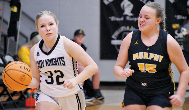 Despite the hot pursuit of Murphy’s Morgan Oliver on Friday, JV Lady Knight Emery Beasley (32) is undaunted in her quest for a basket. Photo by Bella Eddings/The Graham Star