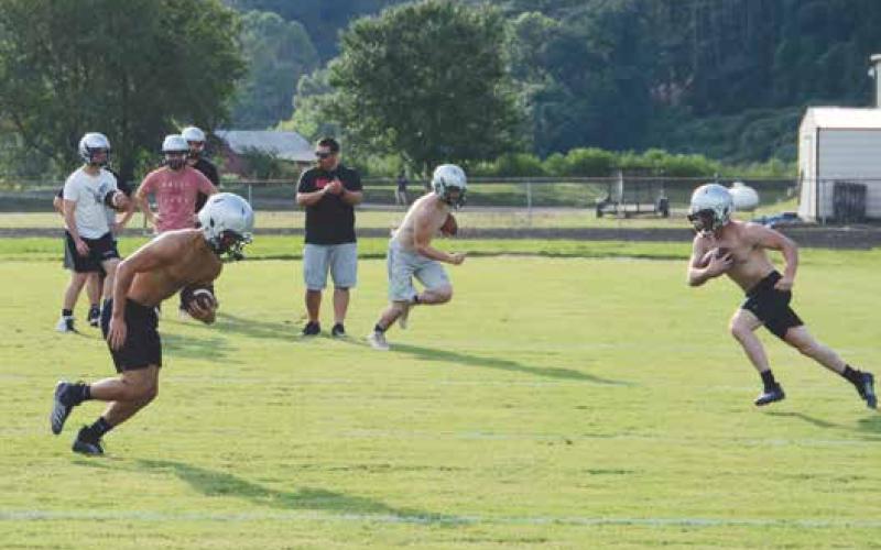 Coach Lucas Ford encourages Rylee Anderson, Bryce Coats and Lex Hooper during an agility drill during the first day of practice Thursday.