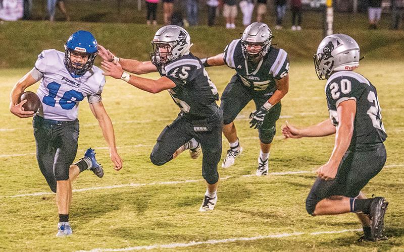 Robbinsville’s Clayson Lane (15), Grady Garland (65) and Lex Hooper close in on Georgia Force quarterback Kyle Moseley during Friday’s non-conference finale. Photo by Byron Housley/The Graham Star