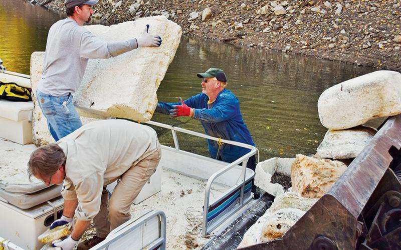 Brian Cable, Greg Davidson and Carl Ferguson (from left) unload just a small portion of trash collected during last weekend’s Fontana Lakes’ Clean-Up. Photo by Art Miller/amiller@grahamstar.com