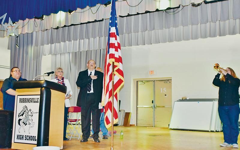As Matthew Miller played “Taps,” Town of Robbinsville Alderman Brian Johnson, Connie Orr of the Graham County Board of Commissioners and Town of Robbinsville Mayor Steve Hooper (from left) honored the flag at the beginning of Monday’s Veterans Day ceremony at  Robbinsville High School. Photos by Art Miller/amiller@grahamstar.com