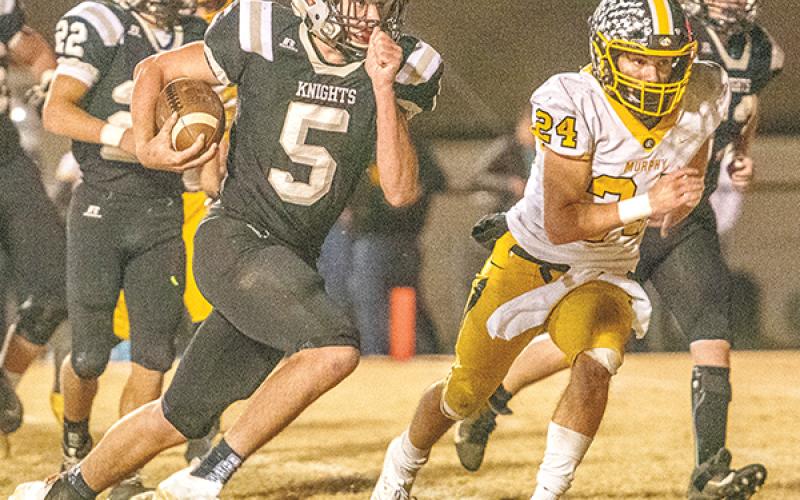 Robbinsville quarterback Nathan Collins (5) looks to outpace the defense of  Murphy’s Ray Rathburn during Friday’s third-round playoff game. Collins had two rushing touchdowns in the Knights’ 24-13 win over the Bulldogs. Photos by Byron Housley/The Graham Star