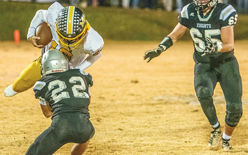 Robbinsville’s Rylee Anderson (22) slows the forward progress of Murphy quarterback Kellen Rumfelt Friday night, which gave Grady Garland (65) the chance to sprint in and help finish the tackle.