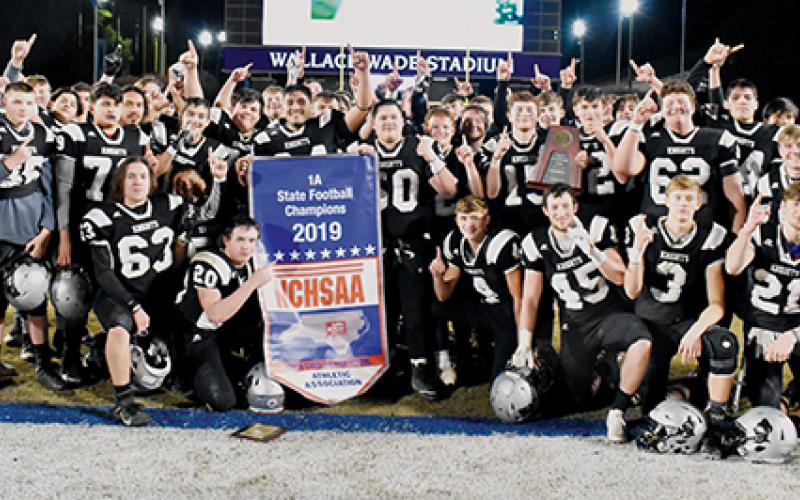 Members of the Robbinsville football team pose with their 1A state championship banner and trophy, after the Black Knights defeated the Northampton County Jaguars 45-14 at Duke University’s Wallace Wade Stadium. Photo by Kevin Hensley/editor@grahamstar.com