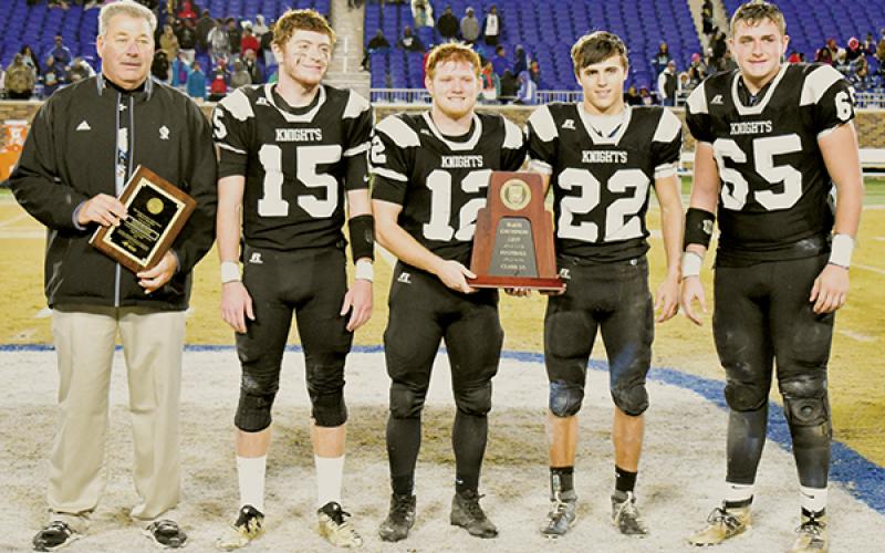 Filled with emotion, Robbinsville head coach Dee Walsh joins Clayson Lane, Kamron McGuire, Rylee Anderson and Grady Garland (from left) in accepting the 1A state championship trophy after Saturday’s win over the Northampton County Jaguars. Photo by Kevin Hensley/editor@grahamstar.com