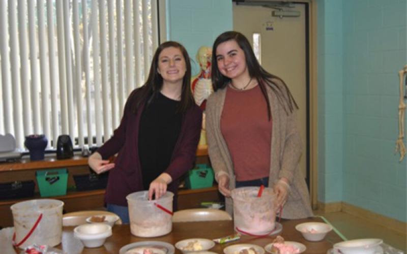 Robbinsville High School HOSA President Emma Nichols (left) and Addison Moody serve ice cream to high school students for reaching the service project goal.