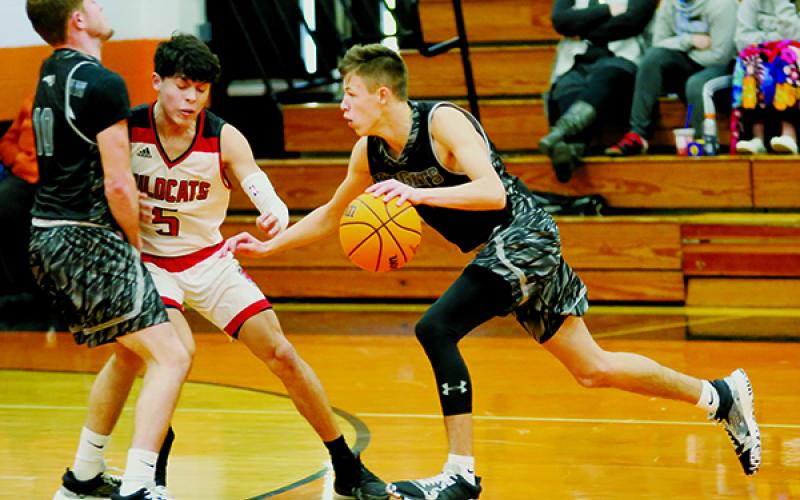 Thanks to Clayson Lane (left) setting a screen on Andrews’ Kabe Ellis, Robbinsville’s Brock Adams finds some open court during Saturday’s Smoky Mountain Conference quarterfinal tournament game against the Wildcats.