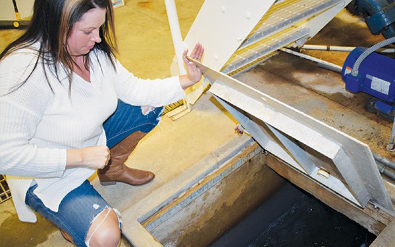 Water Treatment Facility Operator Carrie Stewart  examines the finished water at the Rock Creek  Treatment Plant on Monday. At this point, the water has  already went through several treatments and filters before being pumped into the main tank for distribution across Robbinsville. Photos by Art Miller/amiller@grahamstar.com