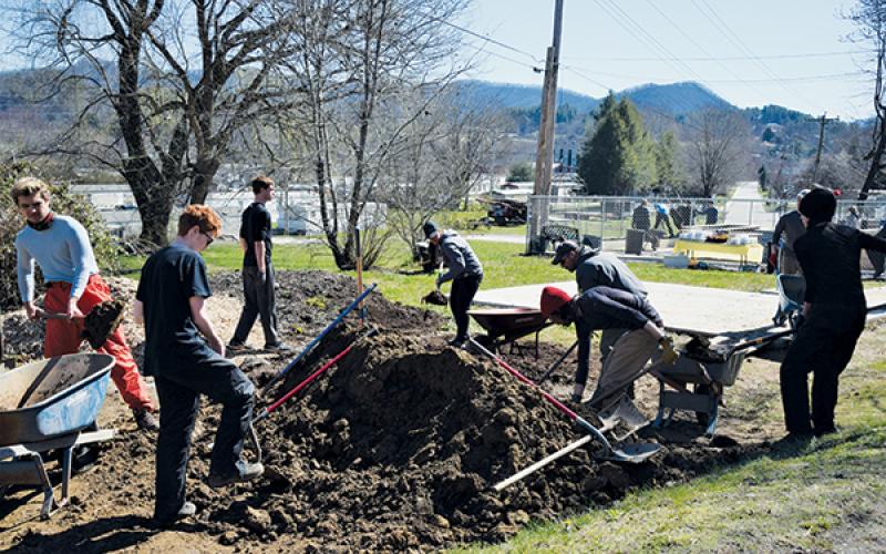 Volunteers work on the new community garden that has sprouted behind the Church Mouse Thrift Store in downtown Robbinsville. Photo by Art Miller/amiller@grahamstar.com