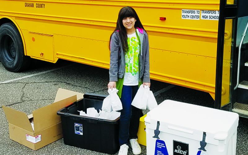 Sarai Moreno, a sixth-grader at Robbinsville Elementary School, took full advantage of the meal distribution program put in-place by Graham County Schools by visiting Robbinsville United Methodist Church for lunch and next day’s breakfast on March 18. Photo by Eric Reece/Contributing Photographer