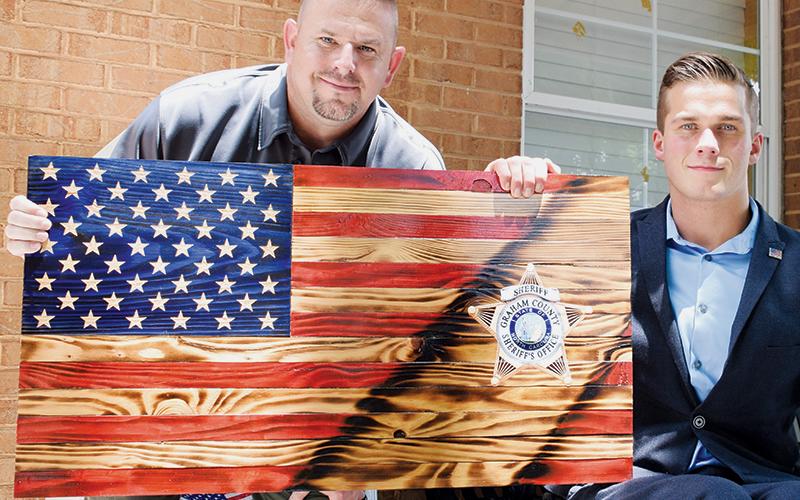Graham County Sheriff Joseph Jones (left) presents Madison Cawthorn with a special wooden plaque after Friday’s meet-and-greet.