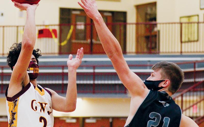 Robbinsville’s Drey Keener (21) reaches out to stop a shot from Cherokee’s Jordan Arkansas during Friday’s 100-81 loss to the Braves. Photo by Scot McKie/Cherokee One Feather