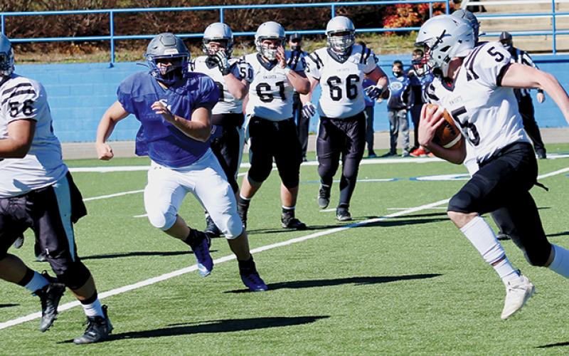 With Carlos Wesley (56) running interference, senior quarterback Nathan Collins takes off on a keeper during Saturday’s scrimmage at Smoky Mountain. Photos by Miranda Buchanan/Robbinsville High School Yearbook