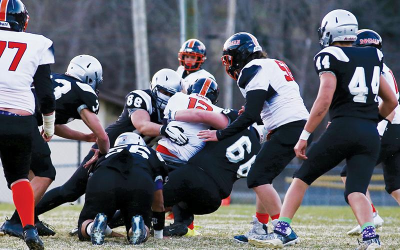 Rossi Wachacha (88) and Haden Key (66) put a stop to the progress of Rosman's Andrew Stamey during Feb. 25's win over the Tigers.