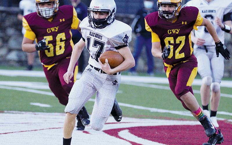 Cooper Adams creates some separation from a pair of Cherokee defenders during the junior varsity Black Knights’ 56-6, season-opening victory over the Braves. Photo by Scot McKie/Cherokee One Feather