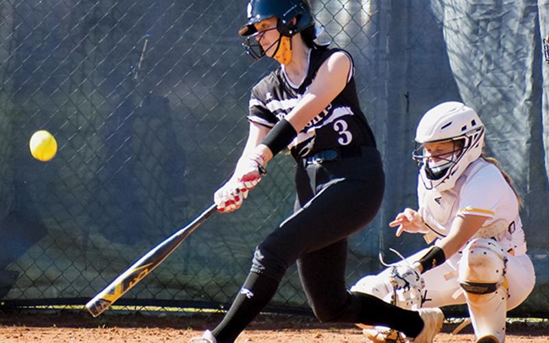 Lady Knights freshman Memory Frapp puts a charge into the ball during Monday’s road game at Murphy. The connection resulted in a double. Photo by Noah Shatzer/Cherokee Scout