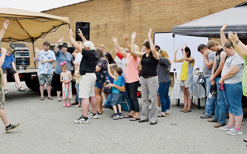 Kevin Seagle leads those gathered at Saturday’s Community Outreach Cookout in prayer. Photos by Art Miller/amiller@grahamstar.com