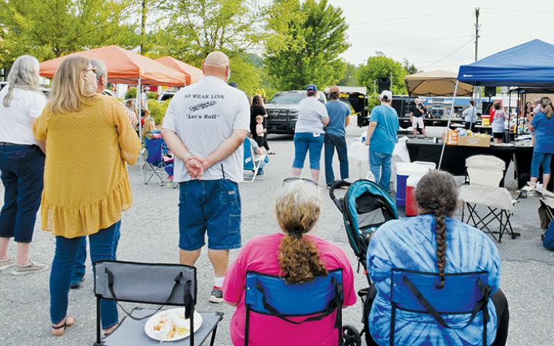 Attendees of Saturday’s Community Outreach Cookout listen as the Rev. Mike Teem addresses the crowd.