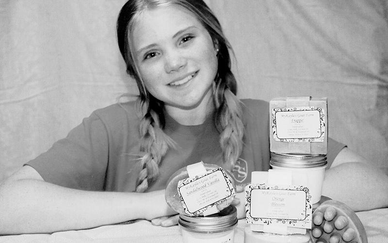 MyKala McGuire shows off a display of products from her goat farm. Photo by Angela McGuire/Contributing Photographer
