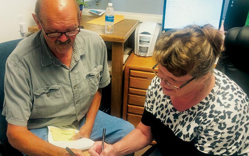 Sitting Robbinsville Mayor Steve Hooper (left) files for re-election with Graham County Board of Elections Director Teresa Garland on July 6. Hooper was the first candidate to file in Graham County for the 2021 general election. Photo by Tasha Holder/Graham County Board of Elections