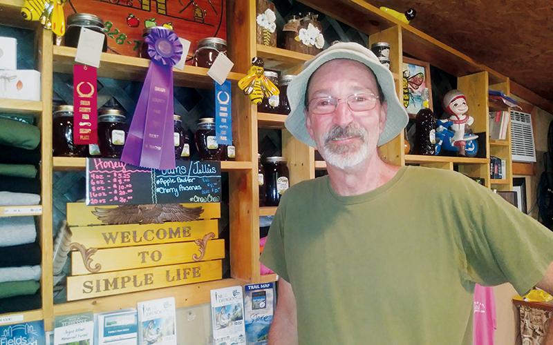 Simple Life Mountain Retreat proprietor Alan Walmsley beams while showing the two awards he won for his honey at the Swain County Agricultural Fair. Walmsley’s sourwood honey took Best in Show and first place, while his dark honey netted a second-place finish. Photos by Charlie Benton/news@grahamstar.com