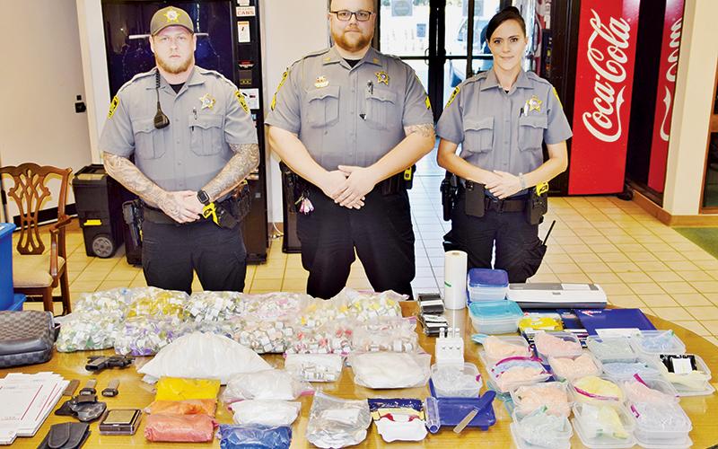 Patrol Officer Jessy Miller, Patrol Sgt. Graham Page and Patrol Officer Alexandria Parris stand with items seized after a Sept. 23 license check, which led to the arrest of Acworth, Ga. resident Michael Thomas Garcia. Photo by Art Miller/amiller@grahamstar.com