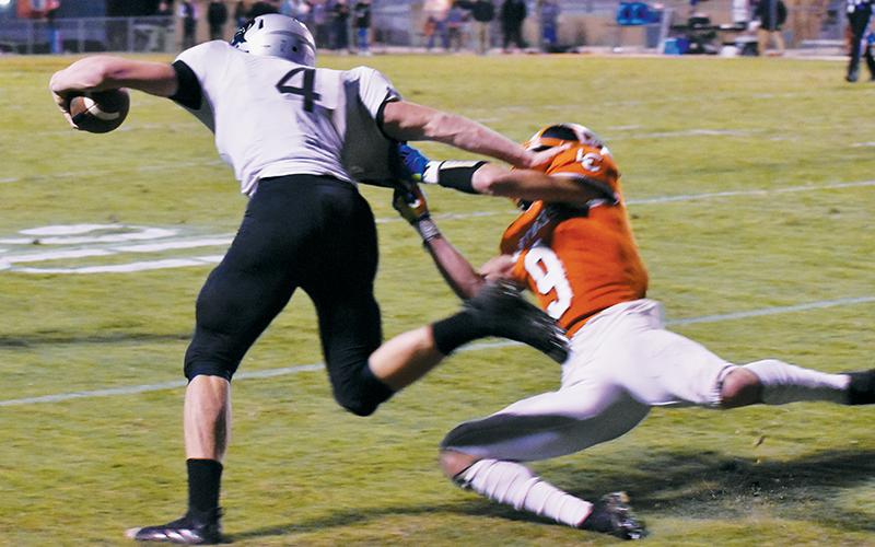 Cuttler Adams (4) denies Lenoir City’s Zane Ward on a third-quarter reception run Friday.