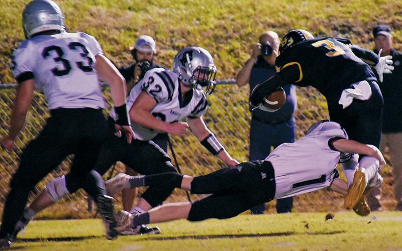 With Jude Campbell (32) closing in, Zeke Silvers (1) slows down the progress of Murphy’s Payton McCracken during Friday’s road game with the Bulldogs.