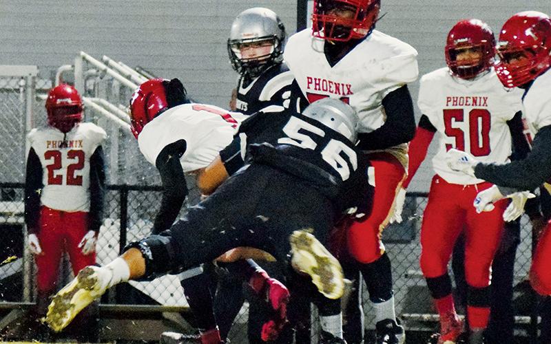 Senior lineman Carlos Wesley drops Winston-Salem quarterback Montell Austin (1) during the first half of Friday’s 66-14 first-round playoff victory over the Phoenix. Wesley had three sacks in the showcase for the Knights. Photos by Art Miller/amiller@grahamstar.com