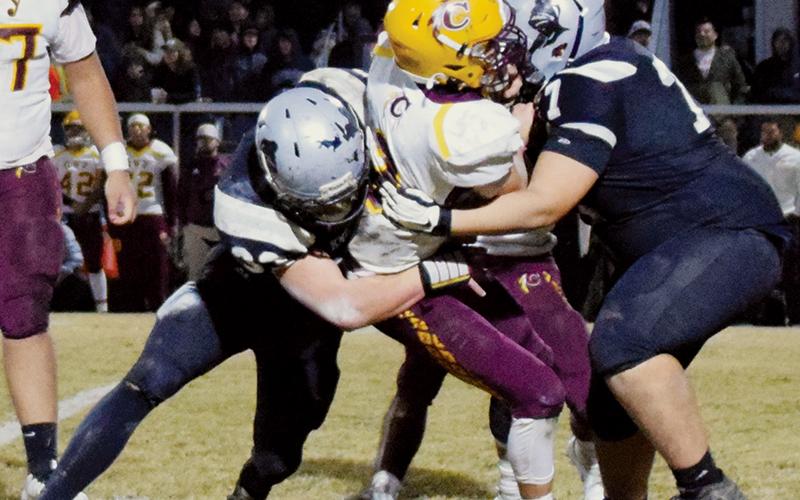 Black Knights sophomore Kage Williams (33) and freshman Tytan Teesateskie (77) sandwich Cherokee quarterback Donald Bradley for one of Robbinsville’s eight recorded sacks Friday against the Braves.