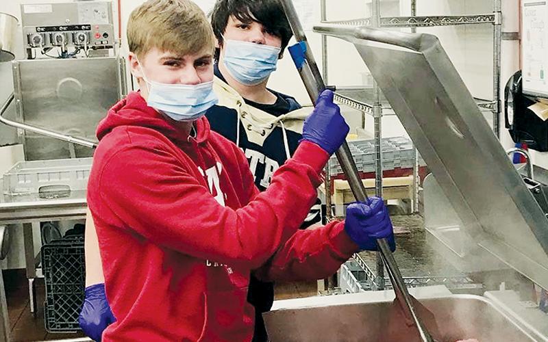 Robbinsville Middle School’s Cooper Adams (front) and Isiac Collins were two of the students that helped feed homeless veterans in Asheville over the Christmas holiday.