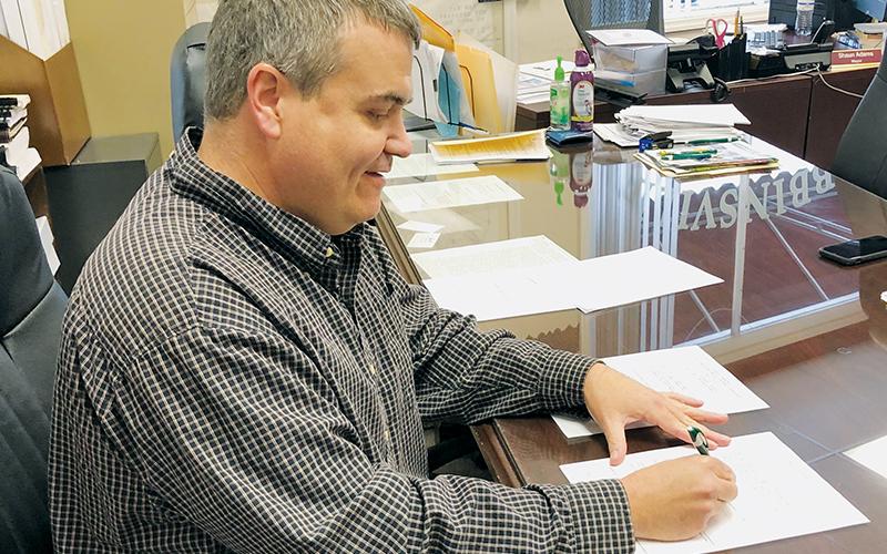 Robbinsville Mayor Shaun Adams signs the first alcholic beverage permit – issued to Ingles – on Jan. 20.