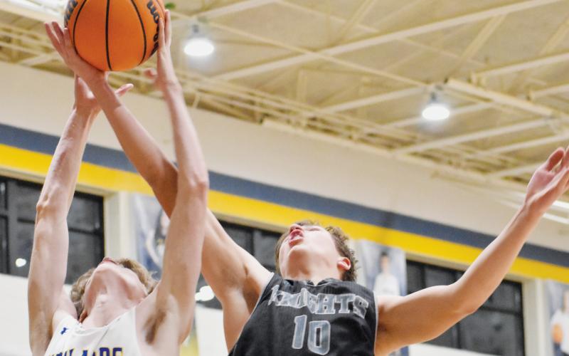 Bryce Adams (10) stretches to out-rebound Highlands’ Kasen Mitchell on Jan. 20. Photo by Kevin Hensley/sports@grahamstar.com