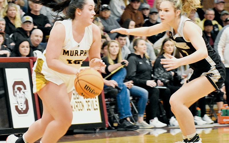 Delaney Brooms (right) keeps pace with Murphy’s Amber Martin during Robbinsville’s Smoky Mountain Conference Tournament finals showdown with the Lady Bulldogs on Friday. Photo by Kevin Hensley/sports@grahamstar.com
