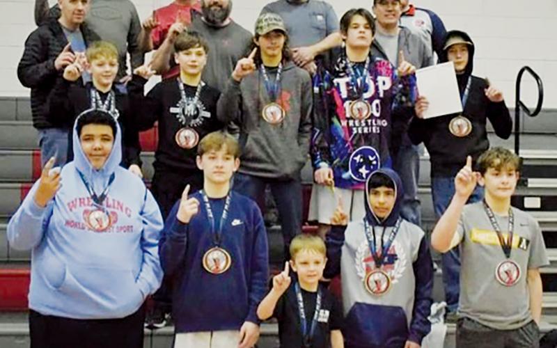 Members of Robbinsville’s youth program take a  moment with coaches and parents to relish their state championship victories on Feb. 5 in Advance. Shown are wrestlers (front row, from left) Bracey Wilson,  Loxston Hooper, Lawton Gibby, Adair Panama and Lleyton Hooper; Benton Gibby, Braydon Lane, Andrew Adams, Kyler Branham and Mason Phillips (second row, from left).