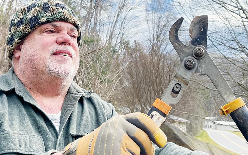 Torey Bennett shows the loppers damaged when he tried to trim limbs overhanging a power line behind his house off Meadow Branch Road. Photos by Randy Foster/news@grahamstar.com