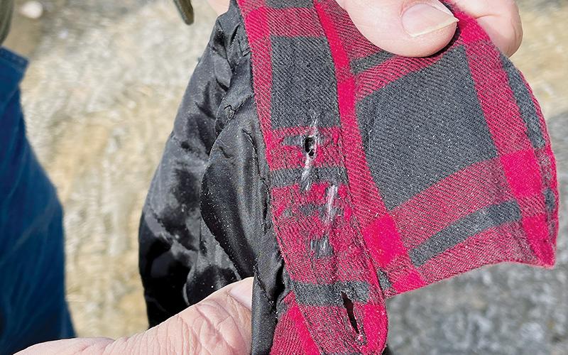 Torey Bennett shows burn marks on the shirt he was wearing when he was trimming tree limbs that were overhanging the power line behind his house off Meadow Branch Road.