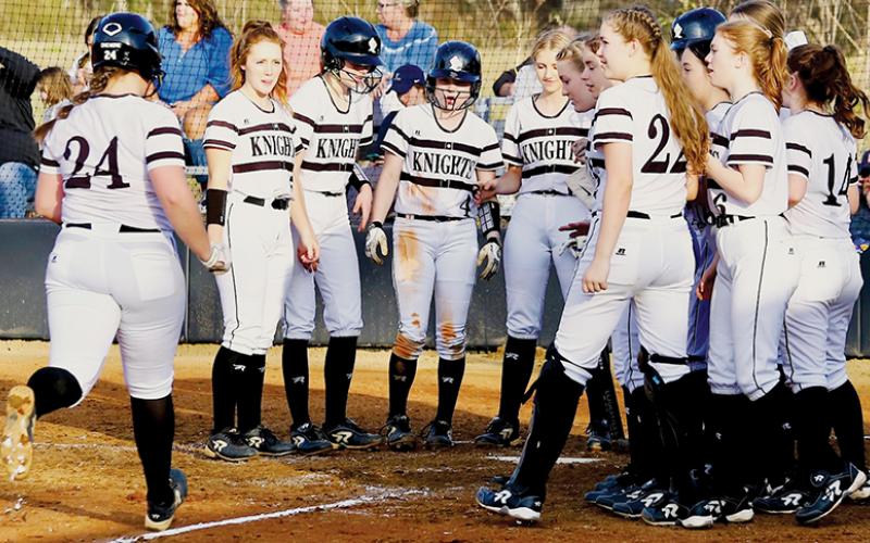 The Robbinsville Lady Knights wait to greet Ivy Odom at home plate, after the senior first baseman slugged one of her two home runs over the fence in Friday’s victory against T.C. Roberson. Photo by Miranda Buchanan/Robbinsville High School Yearbook