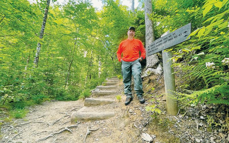 Graham County Search and Rescue Coordinator Tory Lynnes stands at the fork between Joyce Kilmer Loop Trail (left) and Naked Ground Trail (right). Naked Ground Trail is a difficult trail that does not loop. Joyce Kilmer Memorial Forest day hikers sometimes get confused, take the right fork and sometimes have to be rescued. Photos by Randy Foster/news@grahamstar.com
