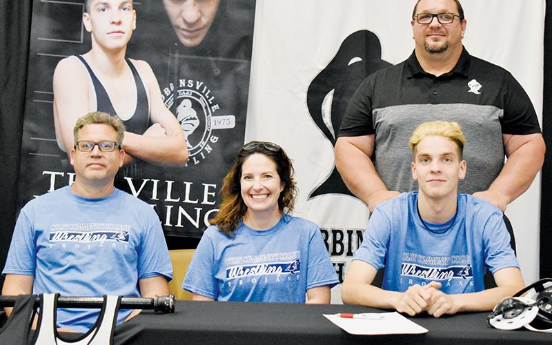 Black Knights senior Zane Lucksavage (seated, right) signed to wrestle for Colby Community College on May 3. Sitting with Lucksavage are father Phil (left) and mother Janelle. Standing in back is recently-retired Robbinsville head coach Todd Odom. Photo by Kevin Hensley/sports@grahamstar.com