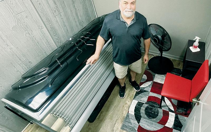 Mac Turkmen unveils one of four tanning rooms he has added to his hair and nails salon on Tallulah Road. Photo by Randy Foster/news@grahamstar.com